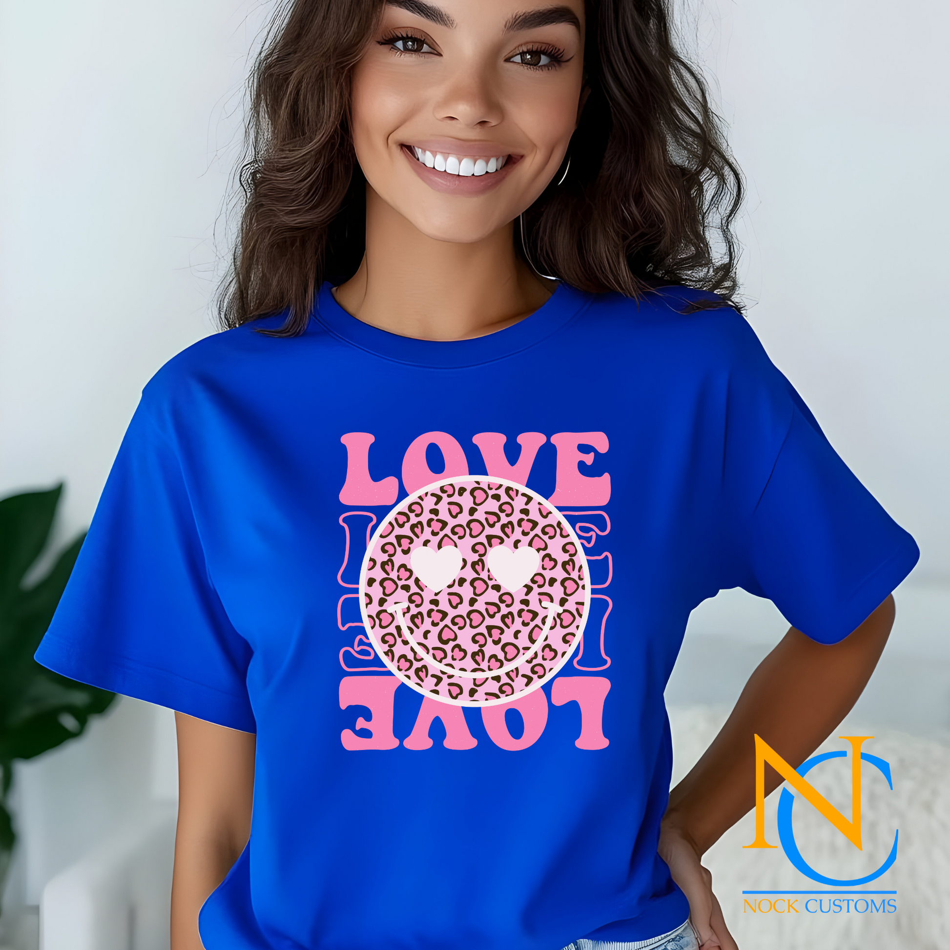 A vibrant pink design featuring a leopard print smiley face with heart eyes, surrounded by the word 'LOVE' in bold pink letters. Perfect for direct-to-film (DTF) transfers on various materials.