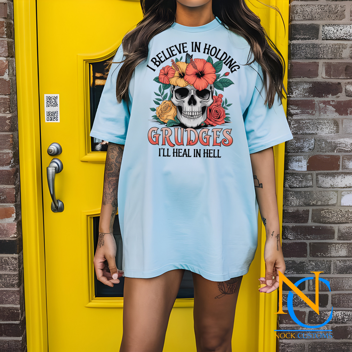 A striking design featuring a skull adorned with vibrant hibiscus flowers, roses, and greenery, with the text 'I Believe in Holding Grudges, I'll Heal in Hell.' Perfect for direct-to-film (DTF) transfers with a bold and sarcastic edge.