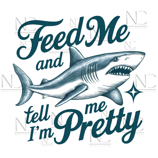 A playful design featuring a fierce shark with the humorous text 'Feed Me and Tell Me I'm Pretty,' complemented by a sparkling star accent. Perfect for direct-to-film (DTF) transfers with a fun and quirky vibe.