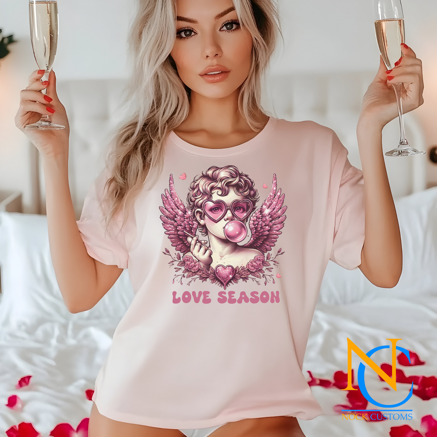 A whimsical design featuring a pink-toned angel wearing heart-shaped sunglasses, blowing bubble gum, surrounded by glittery wings, flowers, and a sparkling heart. The text 'Love Season' completes this romantic and playful design, perfect for direct-to-film (DTF) transfers.