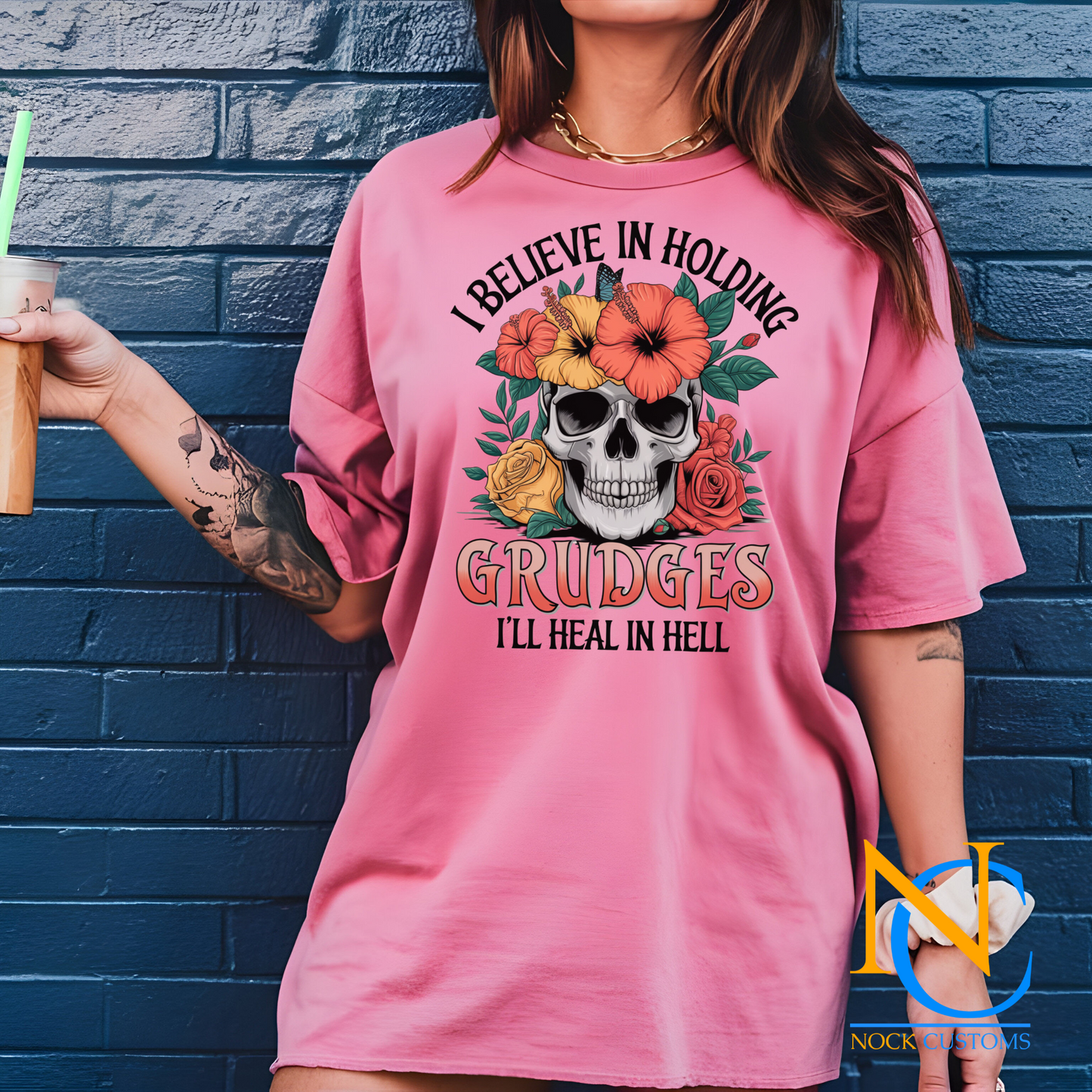 A striking design featuring a skull adorned with vibrant hibiscus flowers, roses, and greenery, with the text 'I Believe in Holding Grudges, I'll Heal in Hell.' Perfect for direct-to-film (DTF) transfers with a bold and sarcastic edge.