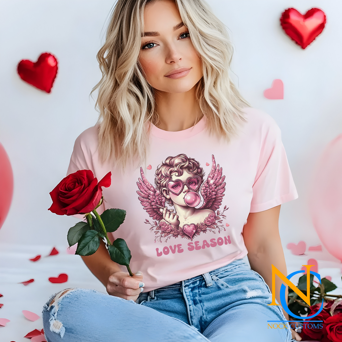 A whimsical design featuring a pink-toned angel wearing heart-shaped sunglasses, blowing bubble gum, surrounded by glittery wings, flowers, and a sparkling heart. The text 'Love Season' completes this romantic and playful design, perfect for direct-to-film (DTF) transfers.