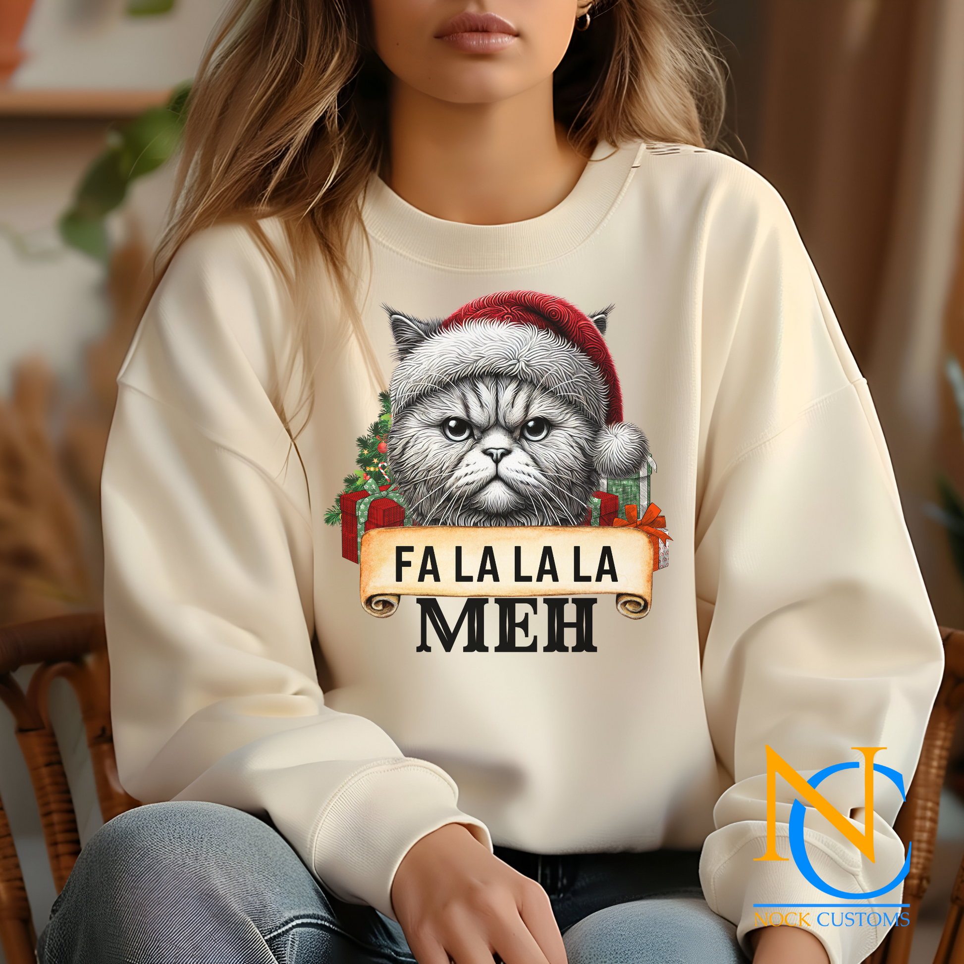 Close-up of a cat-themed holiday design on a hoodie, featuring 'Fa La La La Meh' in festive lettering.