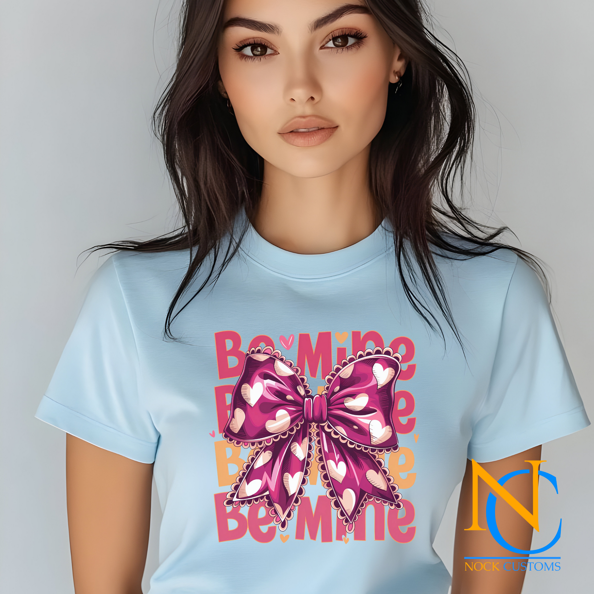 A charming Valentine-themed design featuring a pink bow adorned with white hearts, surrounded by the phrase 'Be Mine' in bold pink and peach letters. Ideal for direct-to-film (DTF) transfers on various materials.