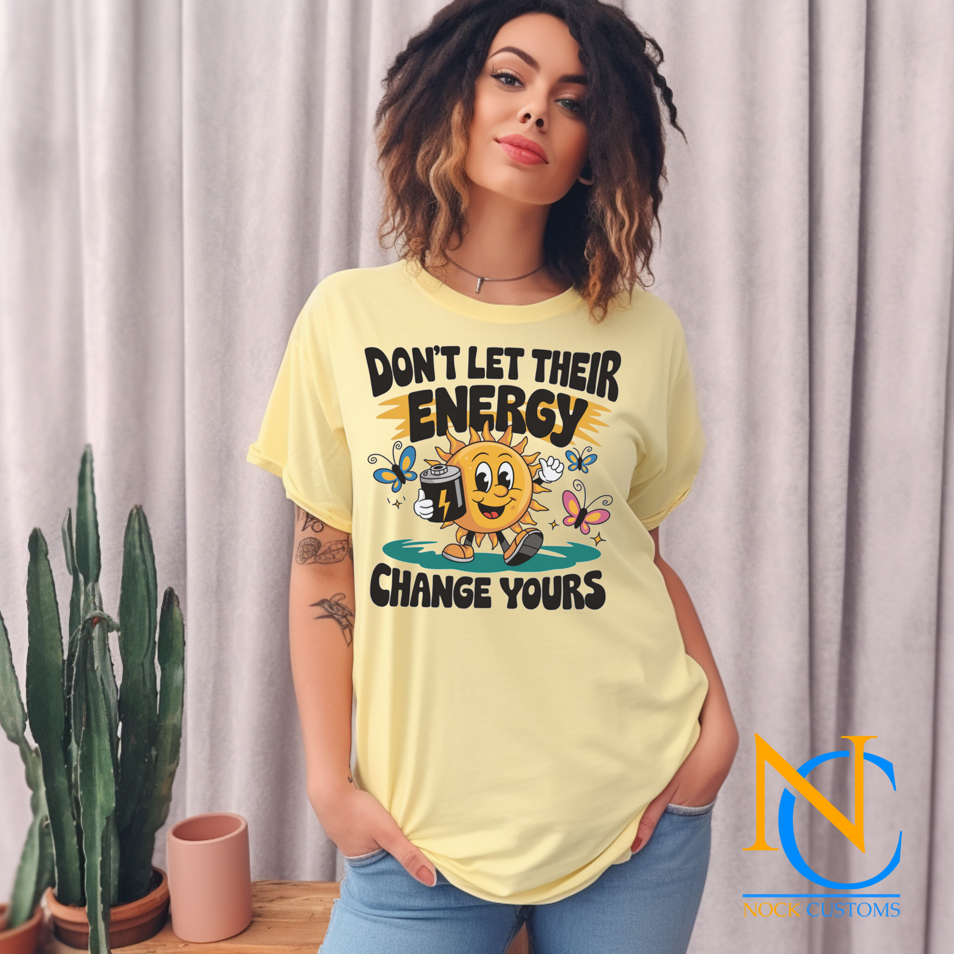 A cheerful design featuring a smiling sun holding a battery, surrounded by colorful butterflies and the text 'Don't Let Their Energy Change Yours.' Perfect for direct-to-film (DTF) transfers with a motivational and uplifting vibe.